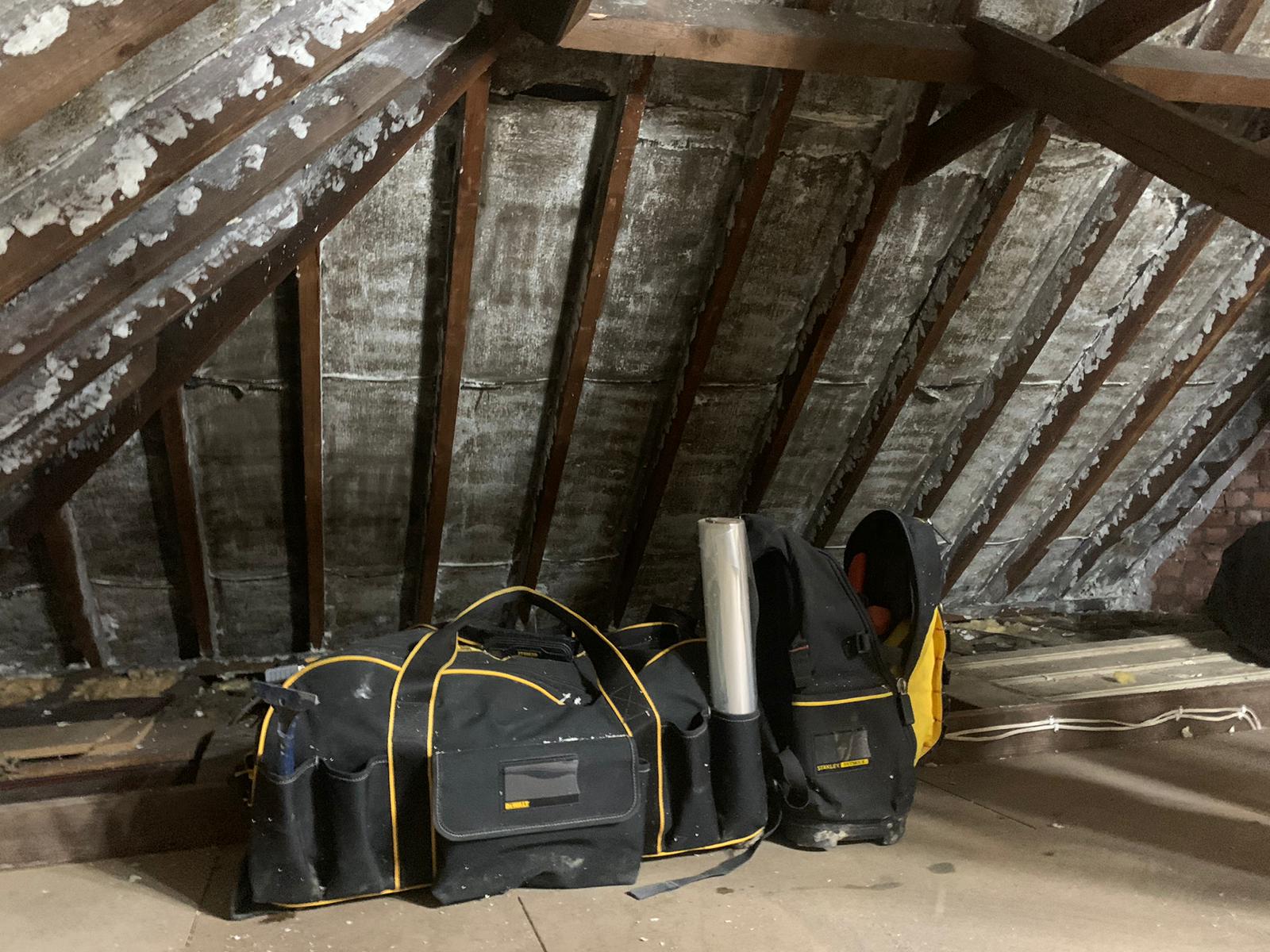 Tool bags in a loft where multi-foil insulation has been fitted between the rafters
